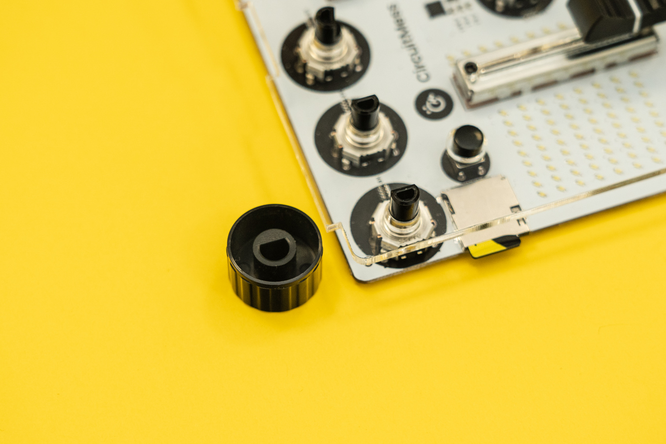 Align the cap to fit the rotary encoder component on the board